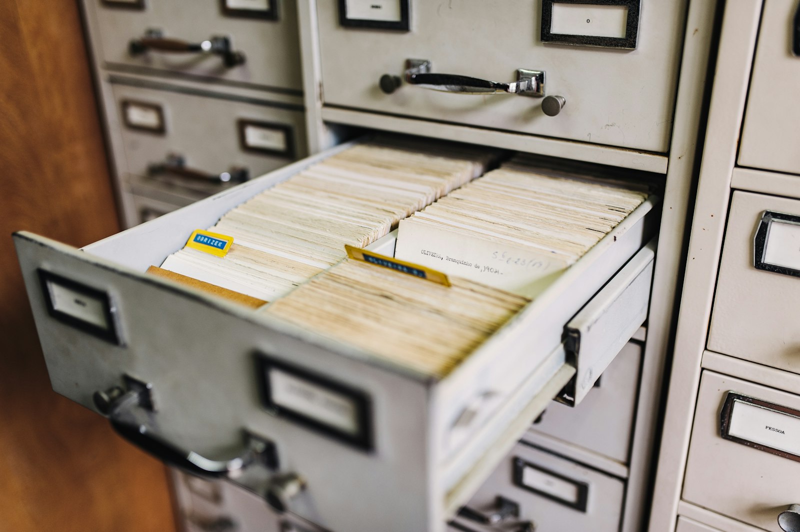 An open metal card-catalog drawer revealing rows of organized index cards.