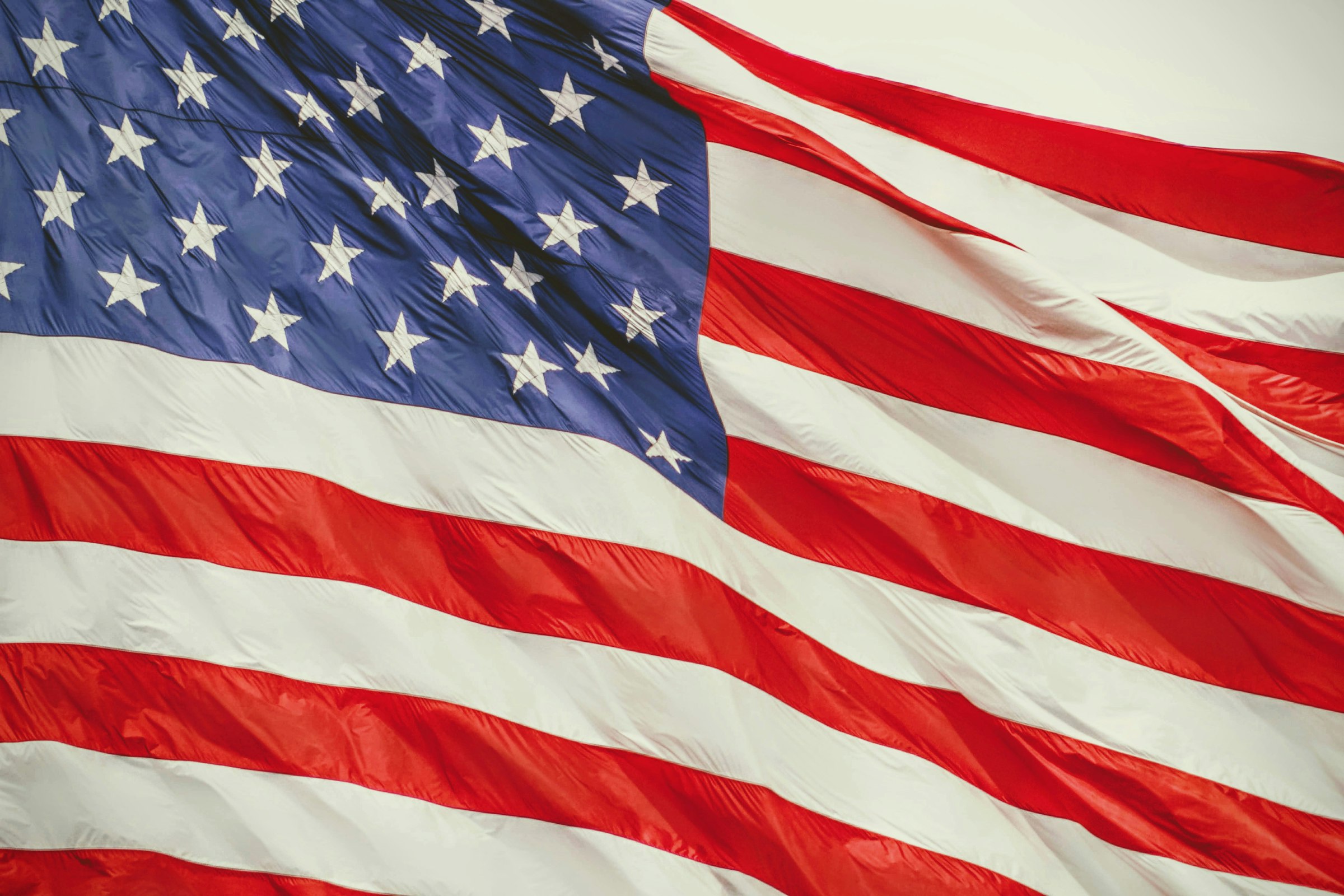 An American flag waving against a clear sky.