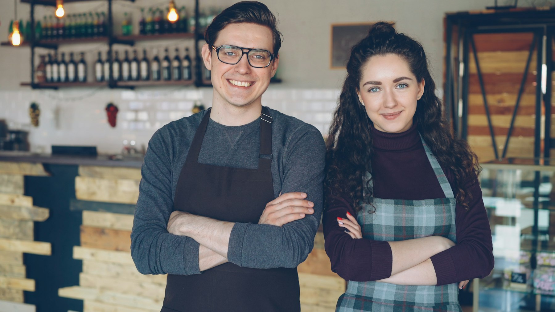 Two small business owners standing together in their shop