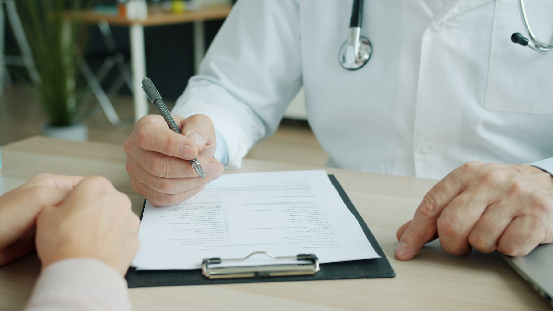 Doctor completing notes on a patient chart