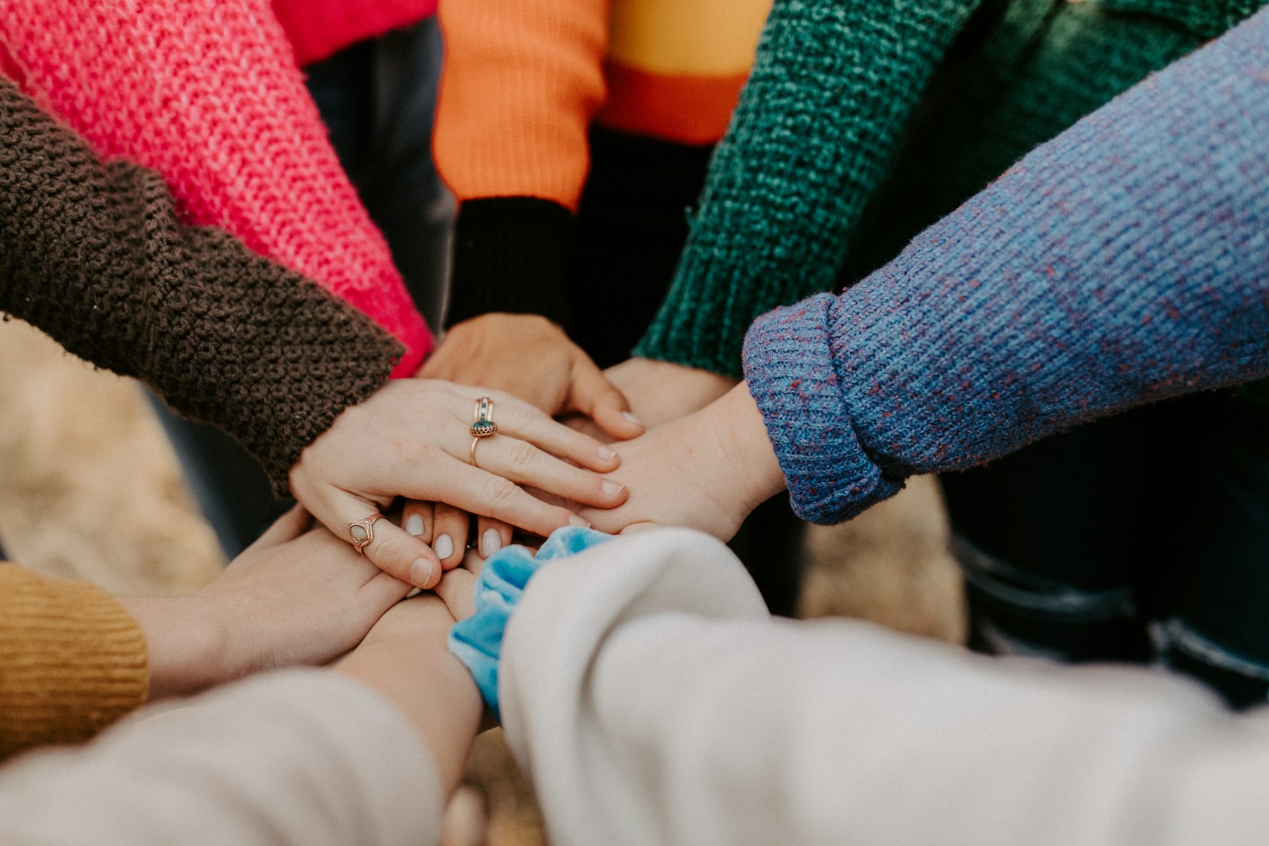 Volunteers joining hands in a team huddle