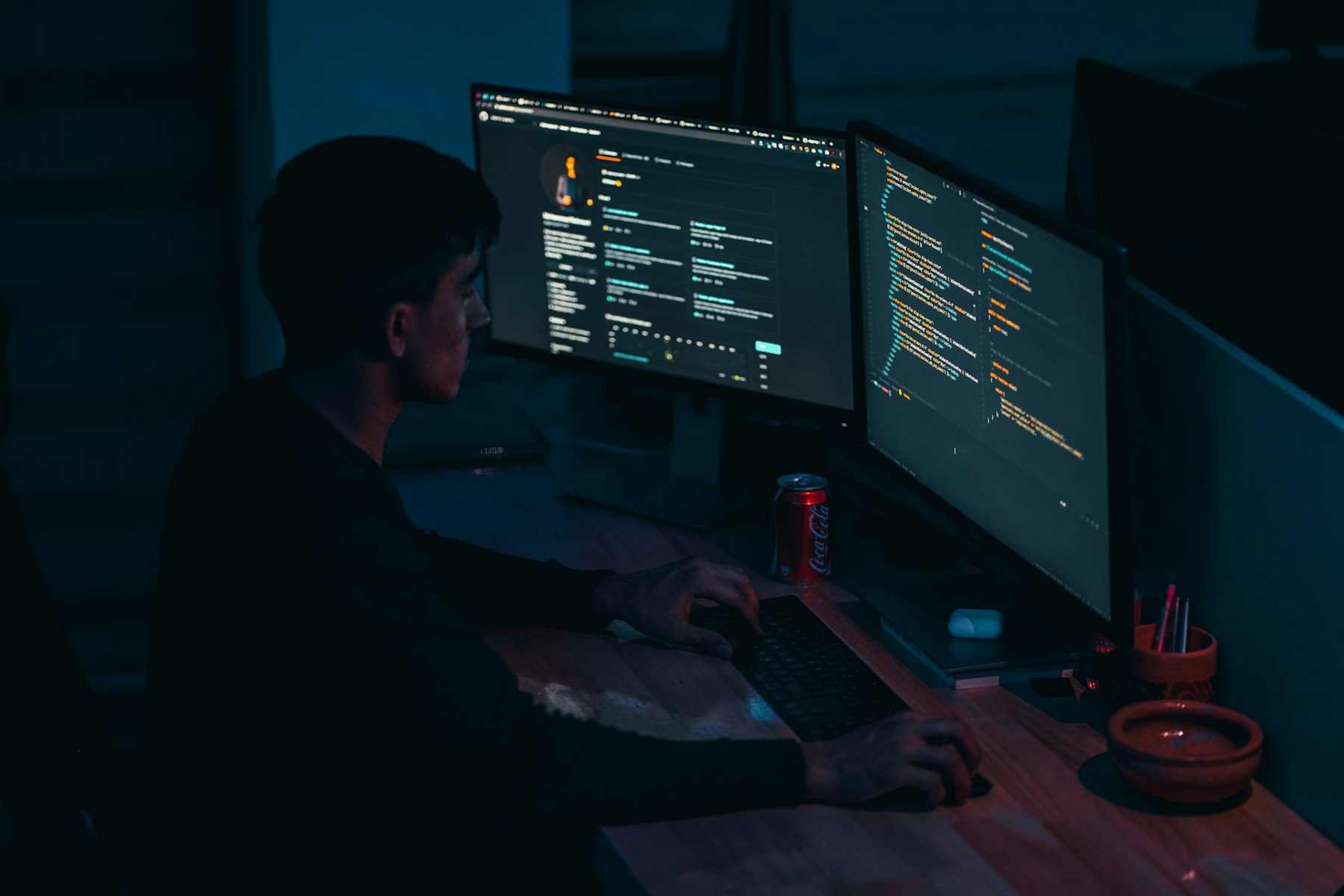 Developer working across multiple computer screens