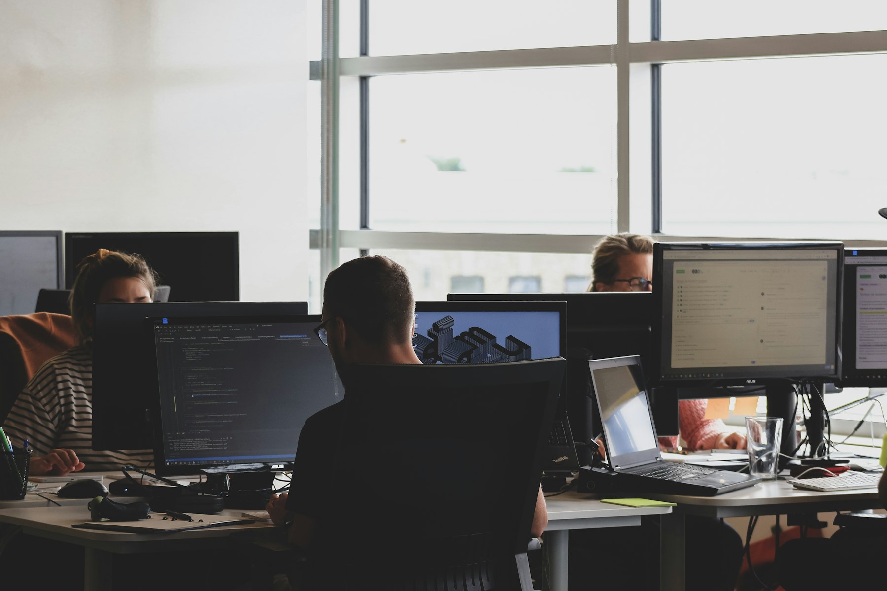 Engineers monitoring systems on multiple screens