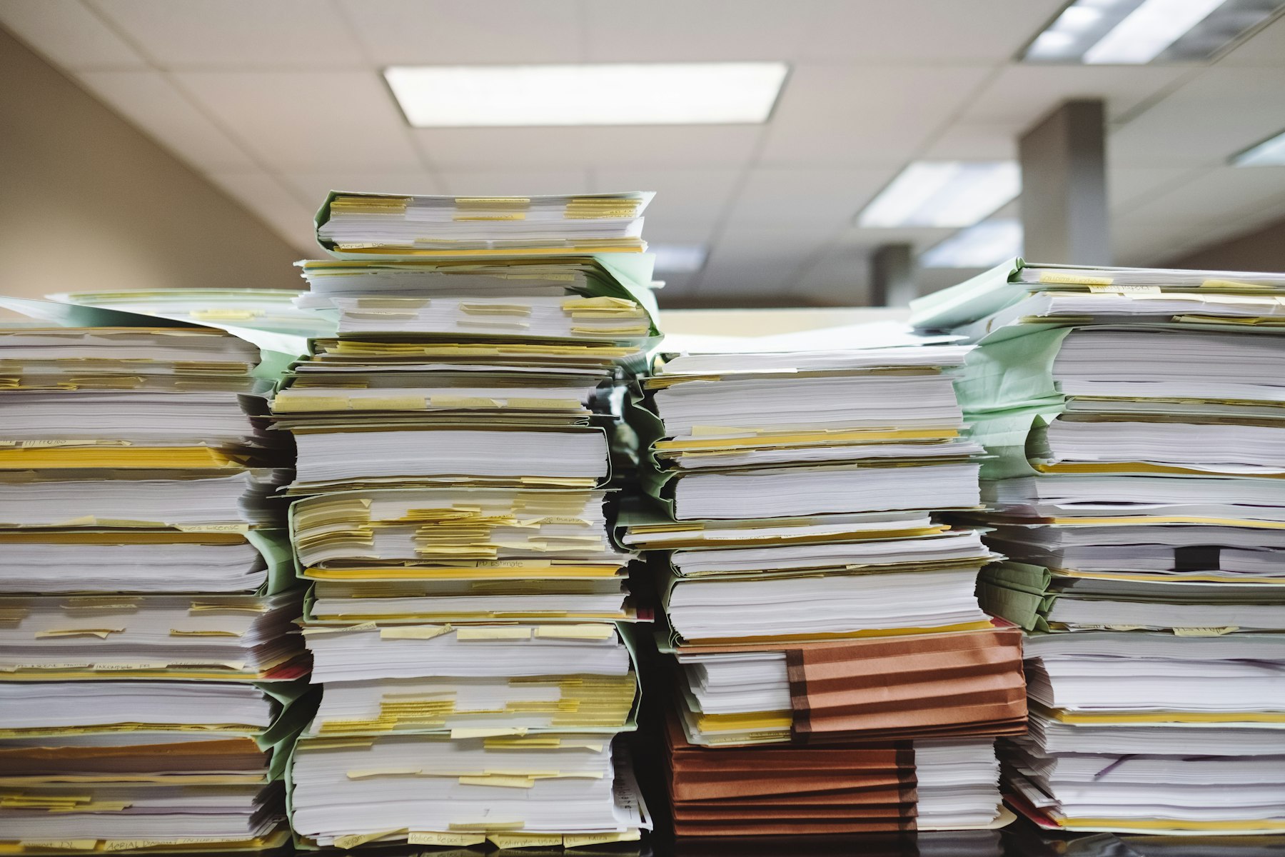 Stacks of paper files waiting to be processed by hand